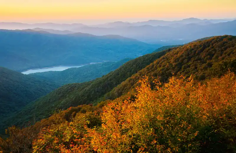 Fall foliage over a lake and valley in the Blue Ridge Mountains near Asheville