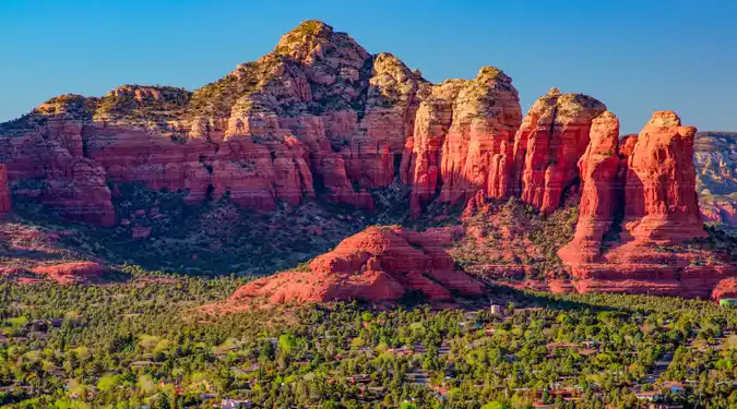Coffee Pot Rock and red sandstone cliffs rising above the town of Sedona Arizona