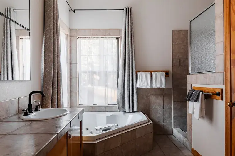 A corner jetted tub beside a window in a room at Black Bear Lodge, South Lake Tahoe.
