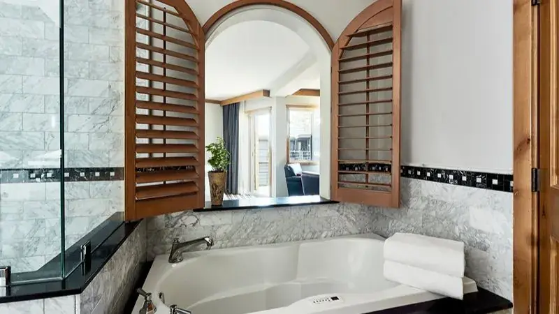 A marble in-room jetted tub with plantation shutters at The Landing Lake Tahoe Resort and Spa.