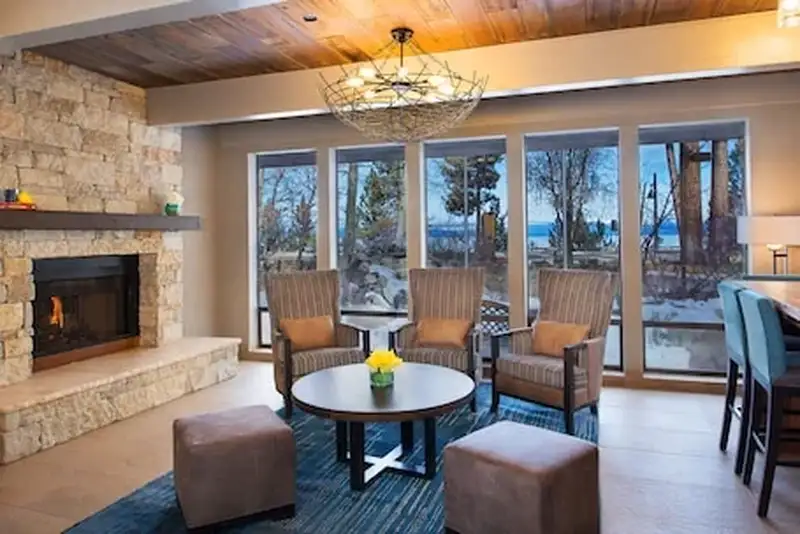 A fireside lounge with lake-view windows at Red Wolf Lakeside Lodge in Tahoe Vista.